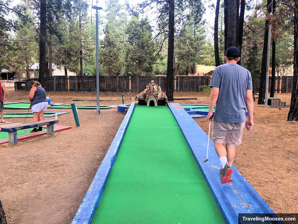 Man walks along hole on mini golf course
